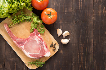 Fresh Raw Pork Chops and vegetable on wooden background.