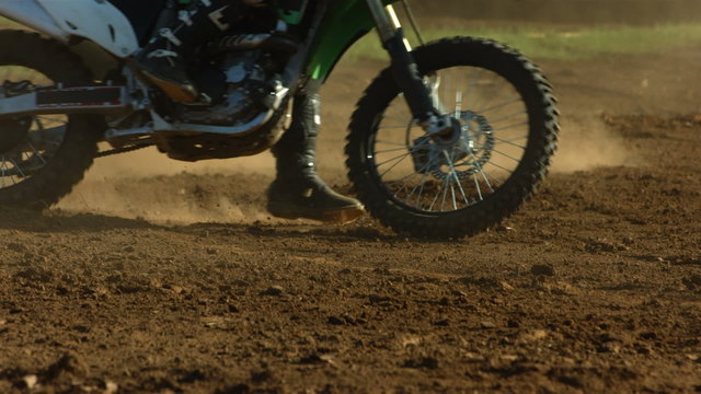 Closeup of motocross bike in dirt, slow motion