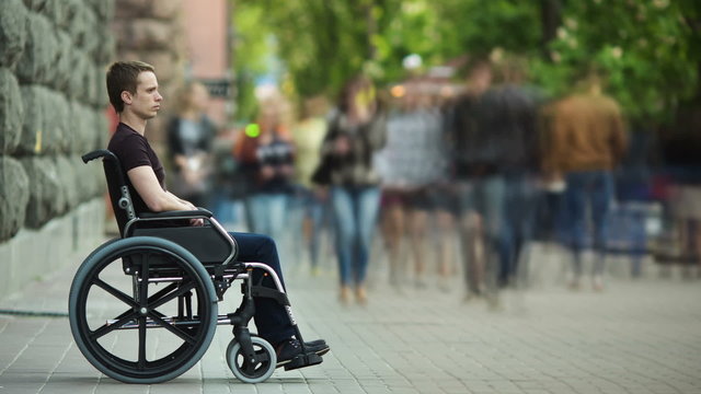 5 in 1 video! The invalid man sit in the wheel chair in the crowd stream at sidewalk. Time lapse with smashed people crowd