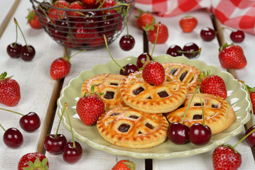 Mini cakes with strawberry and cherry on a white background
