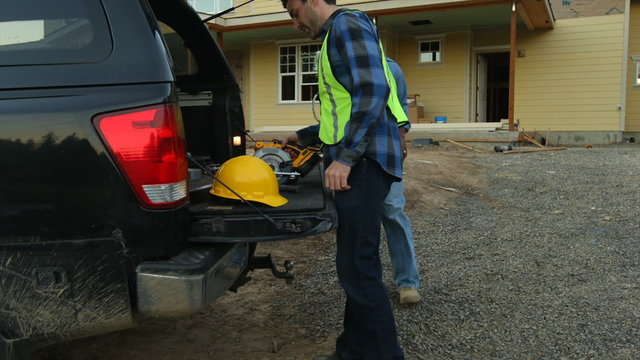 Construction workers get tools from truck