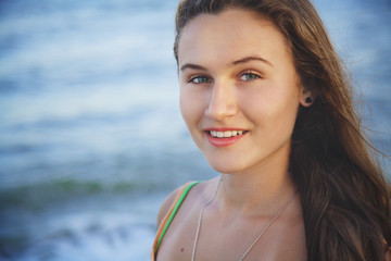 Portrait of young beautiful girl on beach at sunset