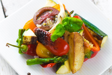 Delicious baked vegetables on a wooden background