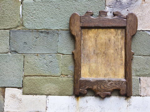 Old wooden frame against a medieval stone wall