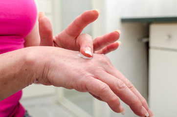 Woman applying cream on her hand