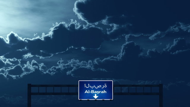 Passing under Al Basrah Iraq Highway Road Sign at Night
  