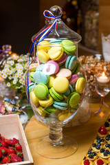 Fresh macaroon in a large glass vase/Macaroon in a glass vase on a table  in сandy bar