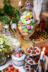 Dessert table at a party with lots of sweets/Macaroon, cake, candy, marshmallows and other sweets on the festive table