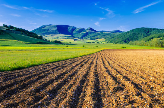 A ploughed field with the Mount Pennino in the background. Photo taken in the Colfiorito plateau, Umbria, Italy