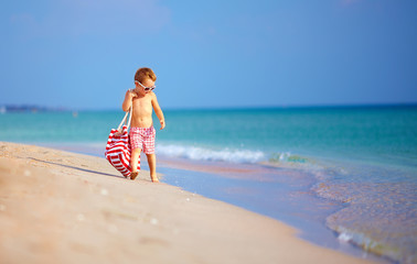 Fototapeta na wymiar cute little kid boy walking the seaside, summer holiday