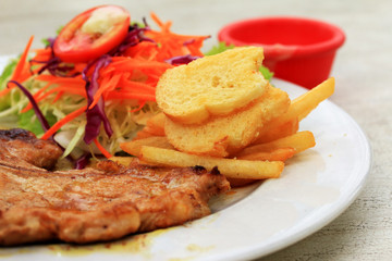 Pork chop, french fries with salad