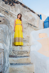 Beautiful girl in a long yellow dress down the ancient stairs in the streets of the old town