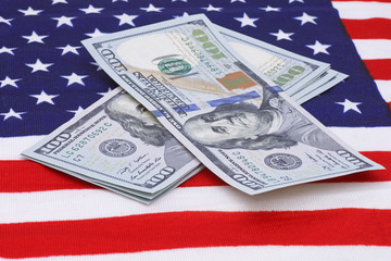 one hundred dollars banknotes on USA flag