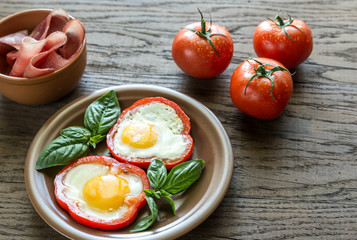 Fried eggs with prosciutto on the wooden table