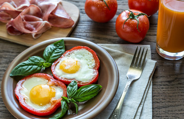 Fried eggs with prosciutto on the wooden table