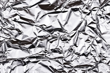 Crumpled wrinkled silver foil texture.