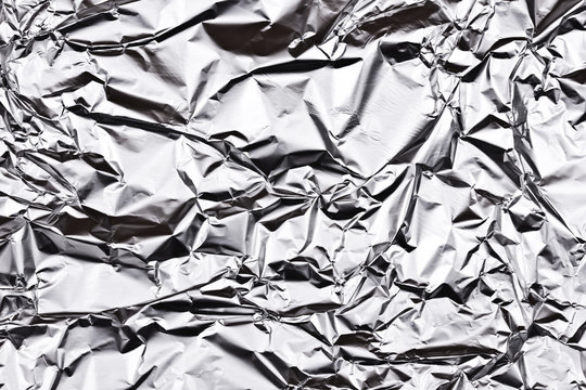 Crumpled wrinkled silver foil texture.