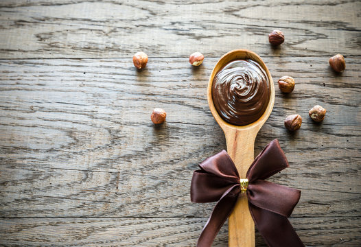Wooden spoon of chocolate cream with hazelnuts