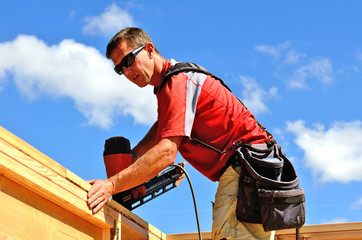 Building contractor worker with a air nail gun  