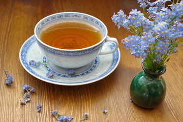 forget me nots in vase with old china tea cup