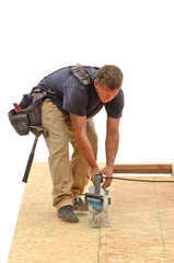 Framing contractor installing roof sheeting over rafters 