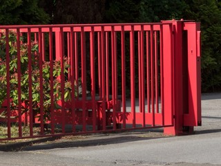 Rotes Stahltor und Schiebetor bei Sonnenschein im Gewerbegebiet in der Sudbrackstraße im Stadtteil...