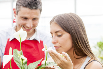 pretty young woman smelling white flower