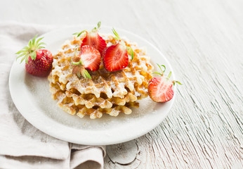 waffles with strawberries on a white plate 