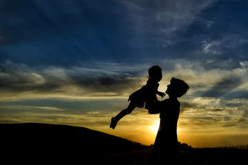 happy mother and daughter having fun at sunset