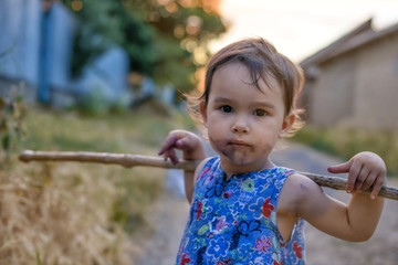 Little and dirty girl with her stick