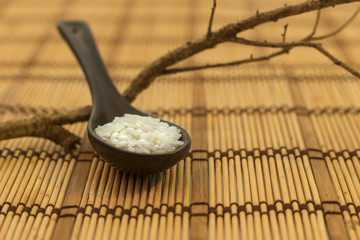 Rice on a black ceramic spoon.