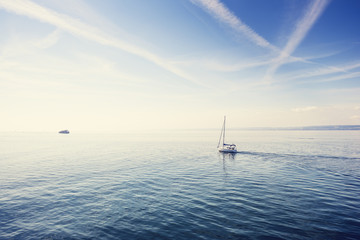 Fototapeta premium Samotna żaglówka na Jeziorze Bodeńskim (Bodensee). Filtr retro.