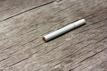 White cigarette on a wooden table