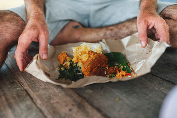 Man holding food on paper in his hands
