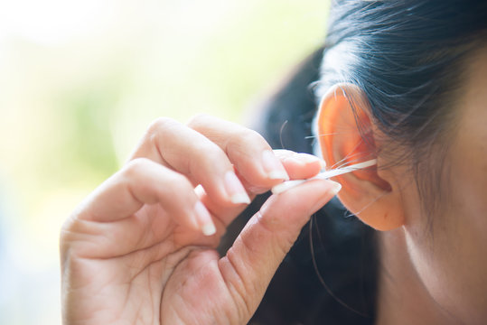 A Woman Cleaning Ear With Cotton Bud