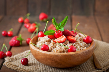 Oatmeal porridge with berries in a wooden bowl