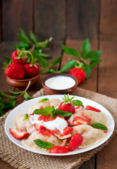 Fresh dumplings with strawberries and sour cream