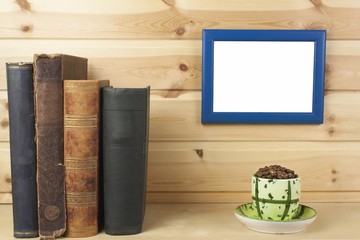 wooden shelf with old books and picture frame for your text.
