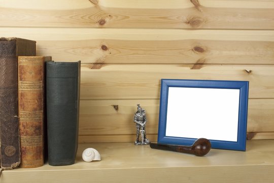 wooden shelf with old books and picture frame for your text.
