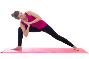 beautiful slim woman standing on pink mat in yoga pose isolated