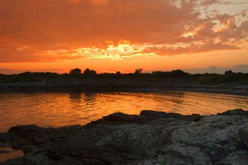 Obraz premium Sunset on a rocky shore.