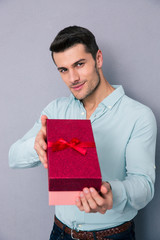 Happy man giving gift box on camera