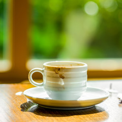 concept of cup coffee drunk and torn paper near the window in th