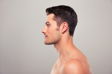 Side view portrait of a young man with nude torso