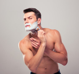 Muscular man shaving