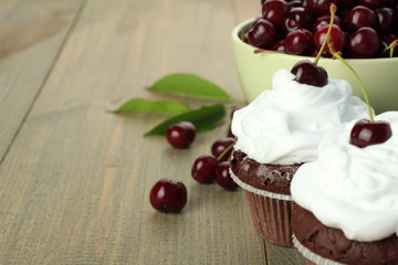 Chocolate Cupcakes with cherries on wooden background