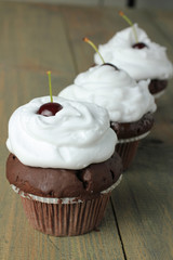Chocolate Cupcakes with cherries on wooden background
