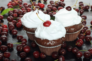 Chocolate cupcakes with cherries on a black background