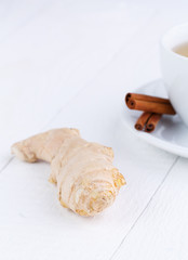Fresh ginger with cinnamon on wooden table.