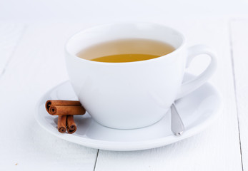Green tea and cinnamon on wooden table.